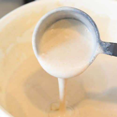 Taking a cup of vegan buckwheat crepe batter.