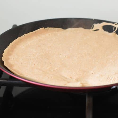 Vegan buckwheat crepe cooking on a pan.