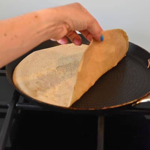 Taking a vegan buckwheat crepe out of the pan.