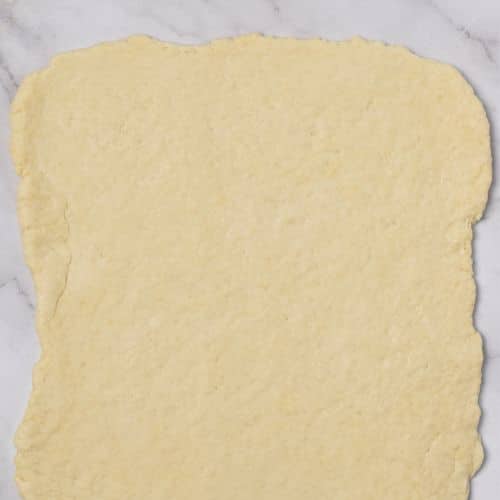 Flattened Yeast-Free Cinnamon Rolls dough into a rectangle.