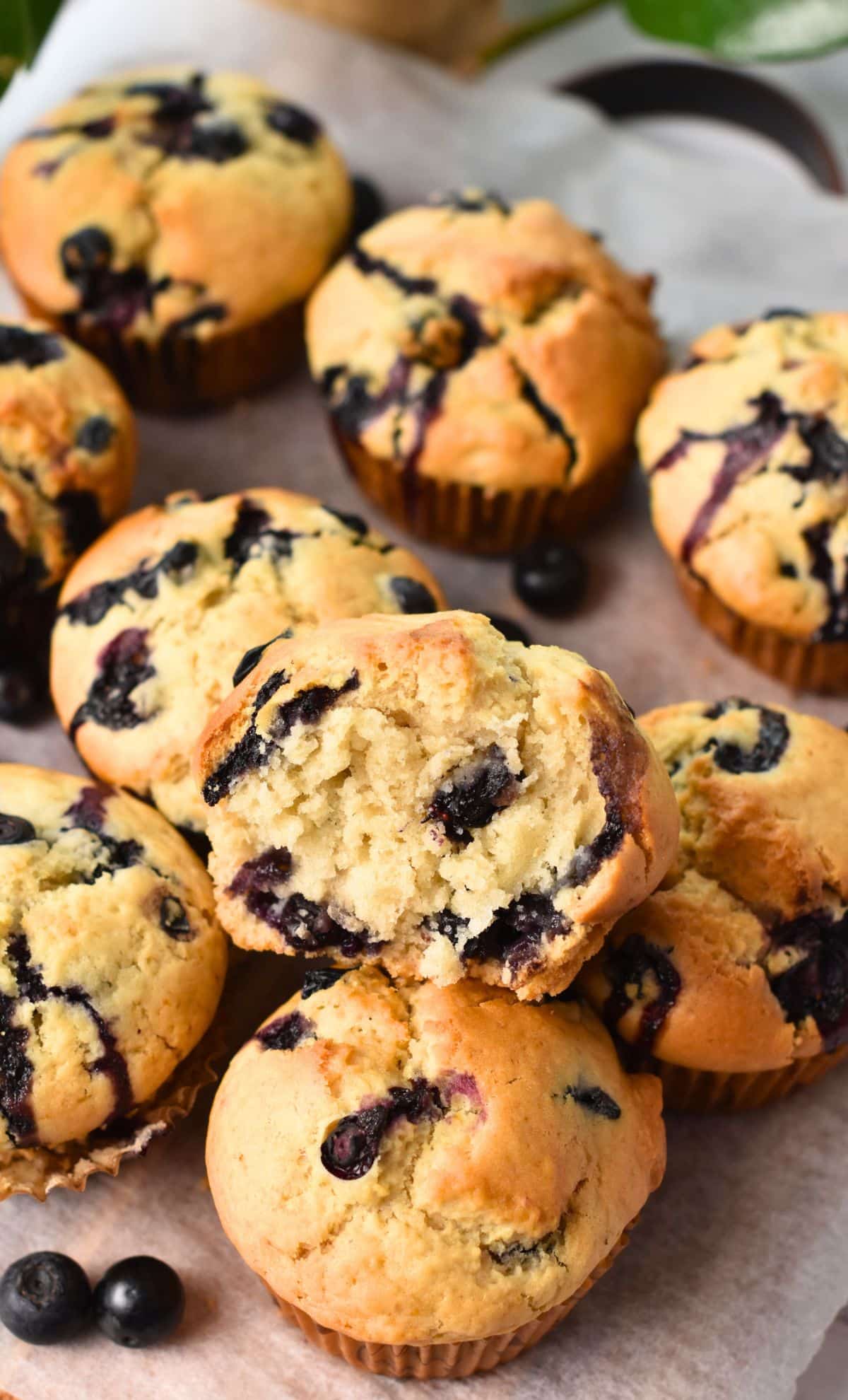 Vegan Blueberry Muffins stacked on a board.