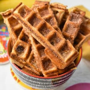 Banana Churros Waffles stacked on a small bowl.