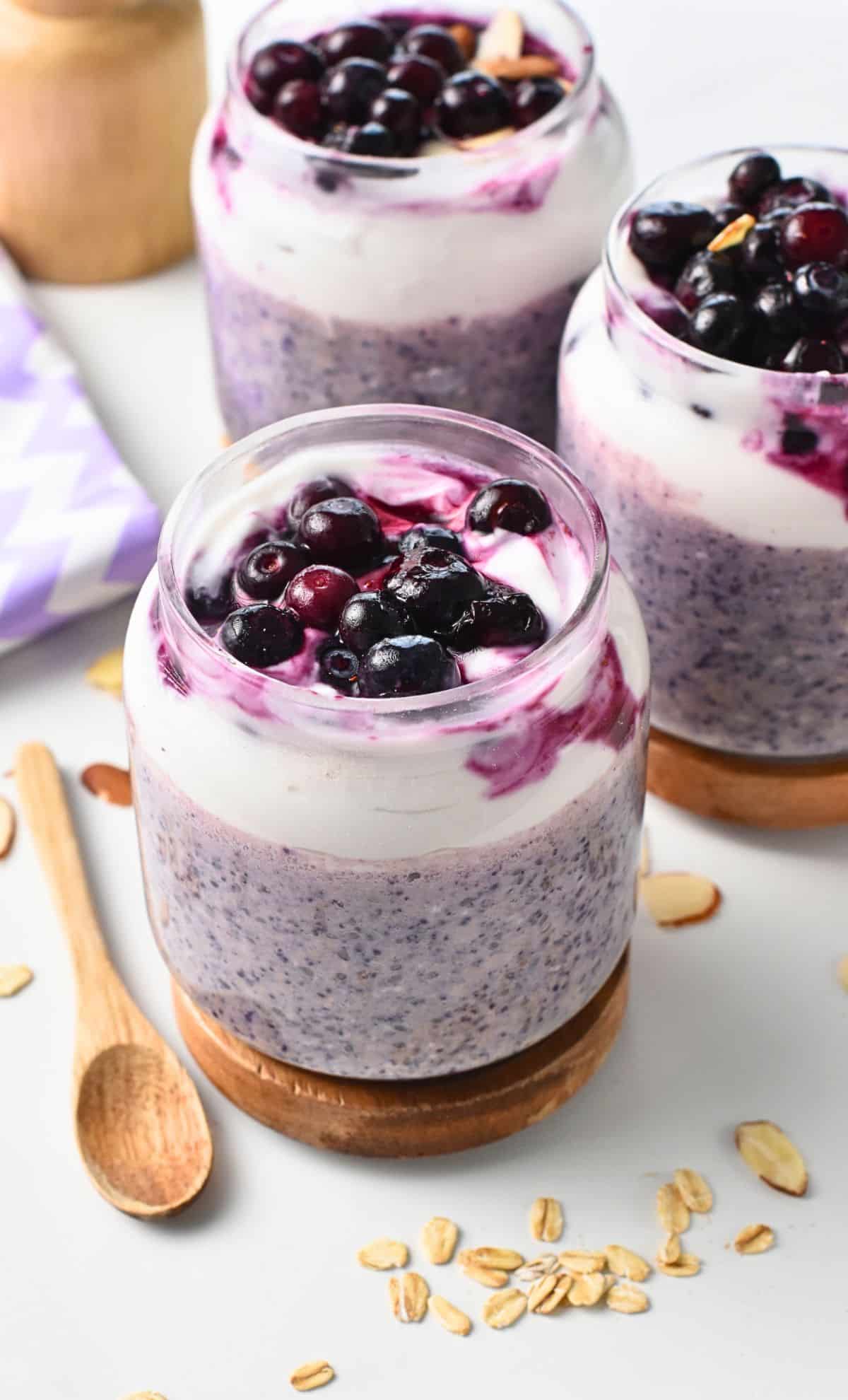 Blueberry Protein Overnight Oats in three jars.
