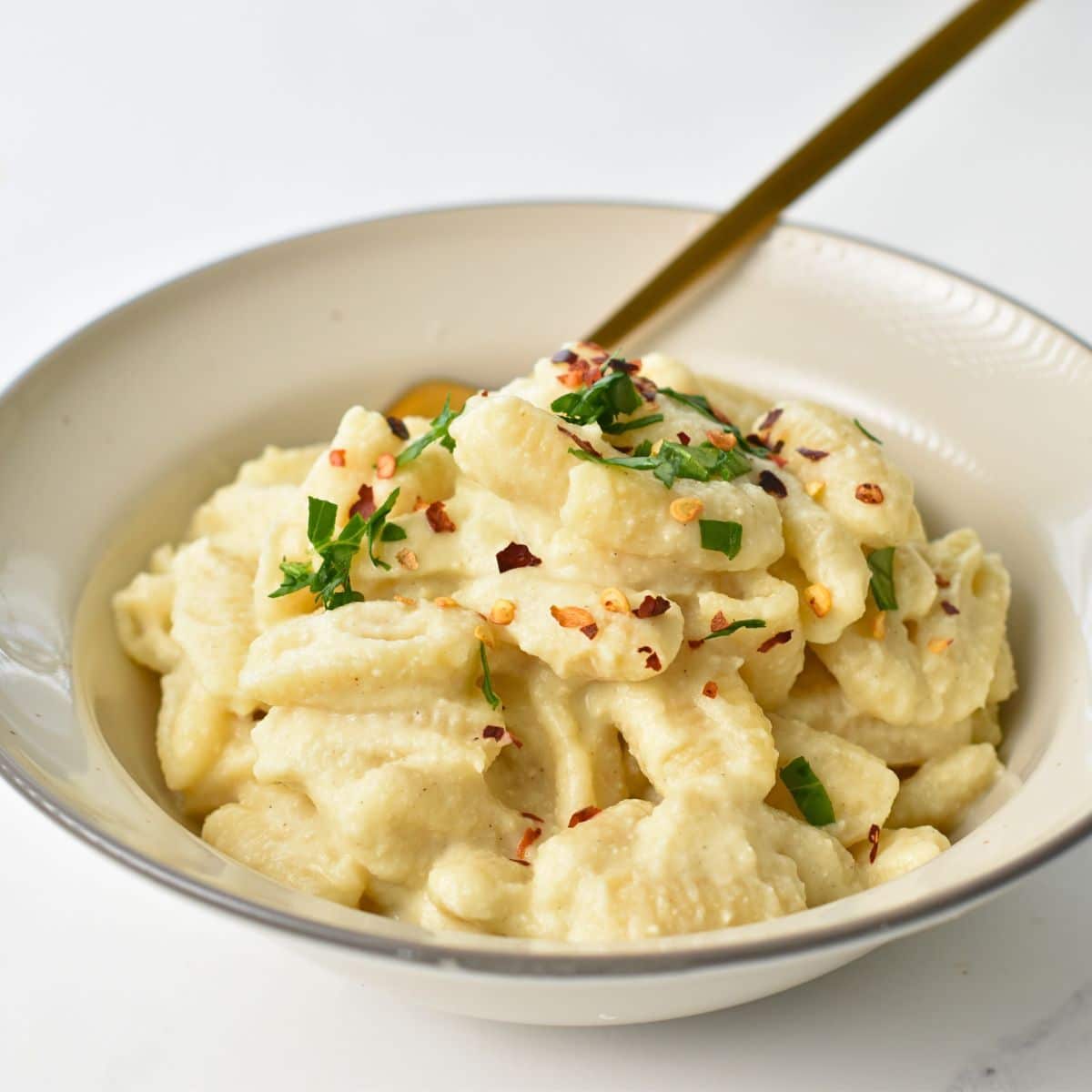 Cauliflower Pasta in a small bowl with fresh herbs.