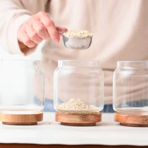 Pouring the oats into 3 glass jars.
