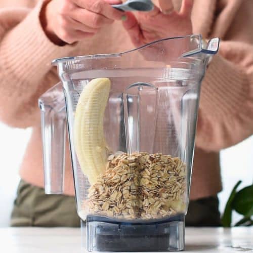 Combining dry High Protein Baked Oats ingredients in a blender.
