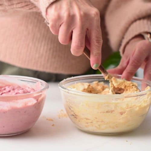 Stirring yogurt and protein powder in a bowl.