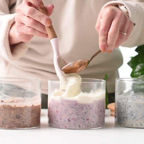 Pouring plant-based yogurt on top of protein overnight oats.