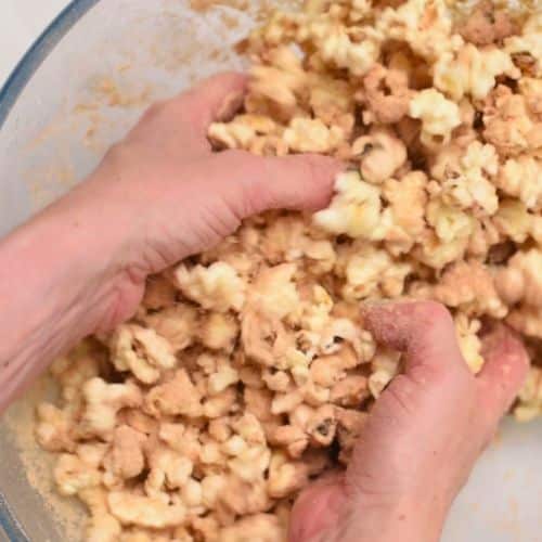 Stirring toppings into popped corn.