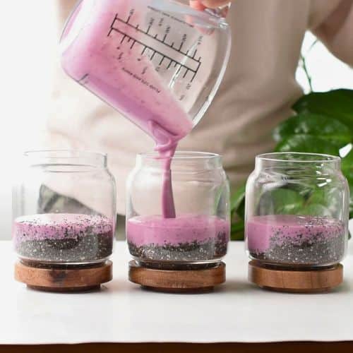 Pouring the pink milk on the chia seeds.