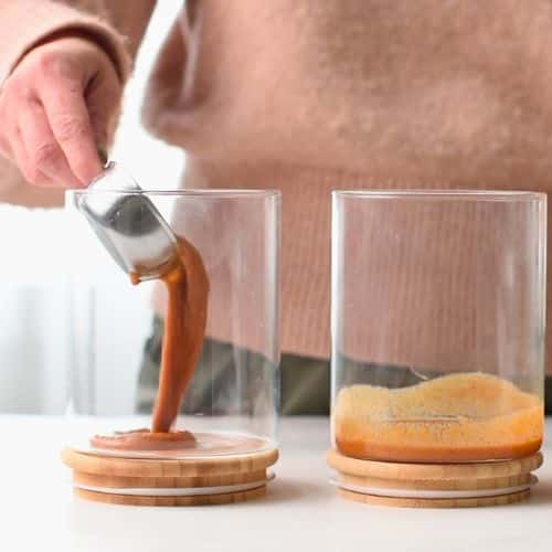 Pouring the Vegan Soba Noodle Salad dressing in glass jars.
