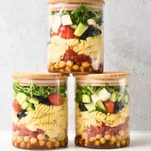 Pasta Salad With Balsamic Dressing in three glass jars.