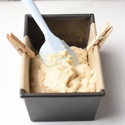 Almond Banana Bread batter in a pan with parchment paper.