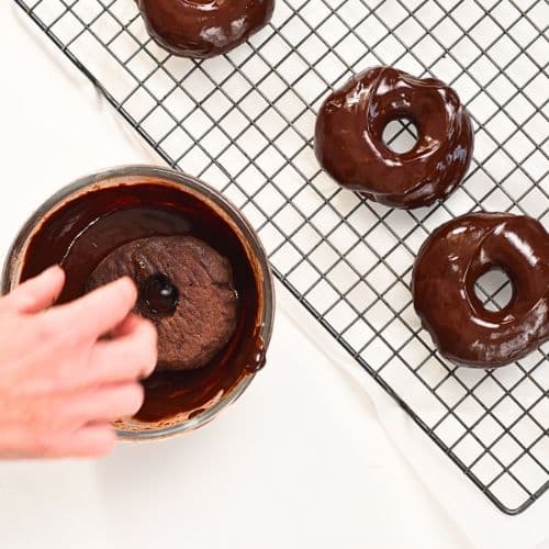 Dipping baked Chocolate Banana Donuts into chocolate ganache.