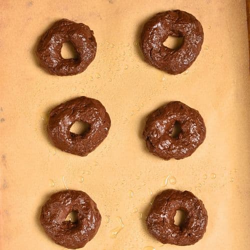 Chocolate Banana Donuts on a baking sheet ready to bake.
