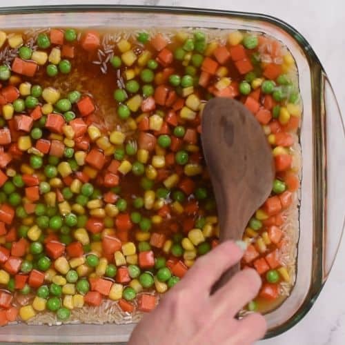 Spreading the veggies on the vegan rice bake