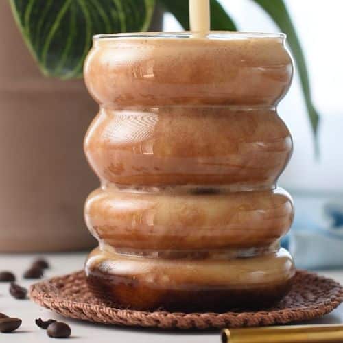 Pouring banana milk into the coffee.