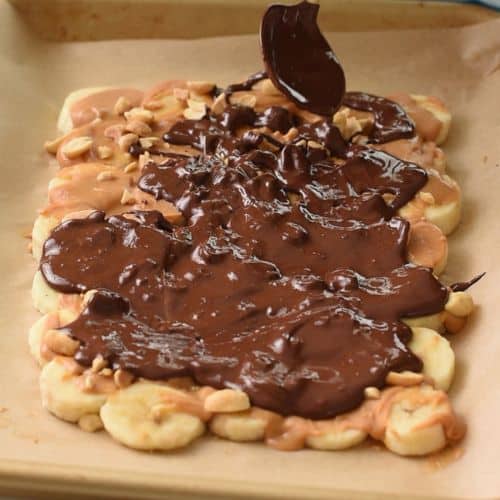 Drizzling melted chocolate on the banana slices.
