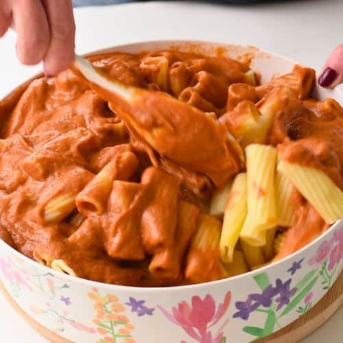 Spreading the Hidden Veggies Pasta Sauce on pasta.