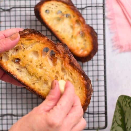Rubbing garlic on toasted bread.