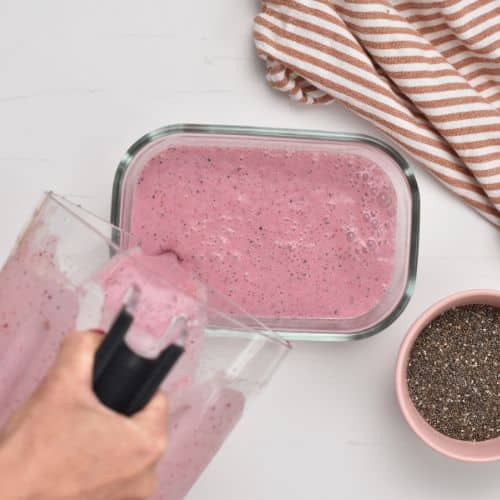 Pouring the berry milk into a container.