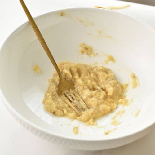 Mashed bananas in a mixing bowl.
