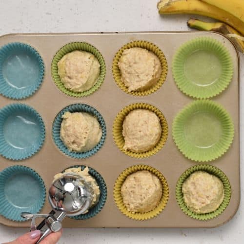 Placing muffin dough into the cases.