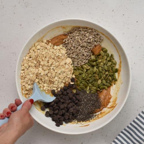 Stirring nuts and seeds in the Crunchy Granola Bite batter.