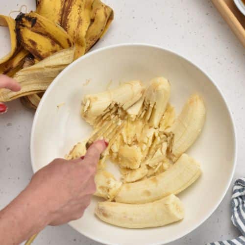 Mashing bananas in a bowl.