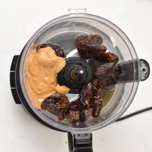 Mixing dates and peanut butter in a food processor.