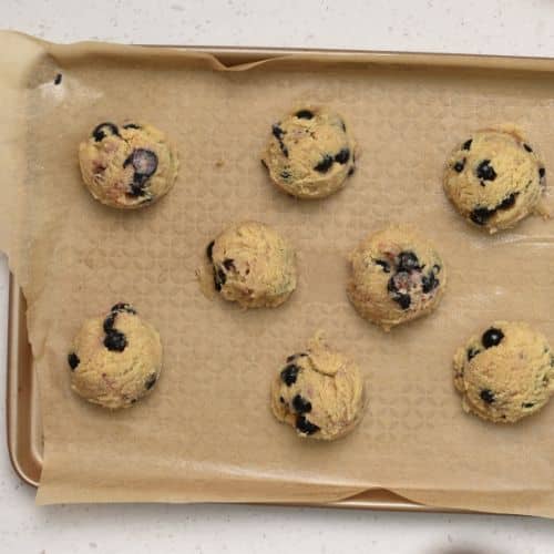 Almond Blueberry Cookie dough balls on a baking sheet.