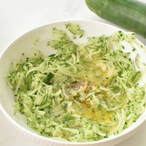 Peel and shred the zucchini in a mixing bowl.