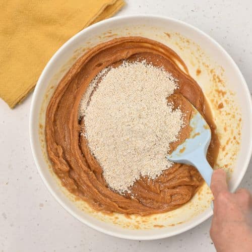 Adding oat flour to the peanut butter mixture.
