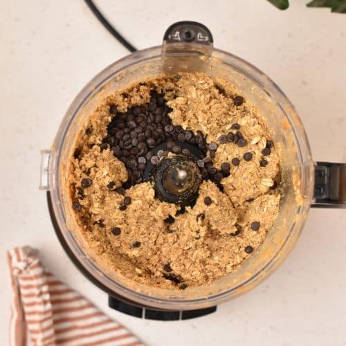 Adding chocolate chips to the Chickpea Protein Bar mixture.