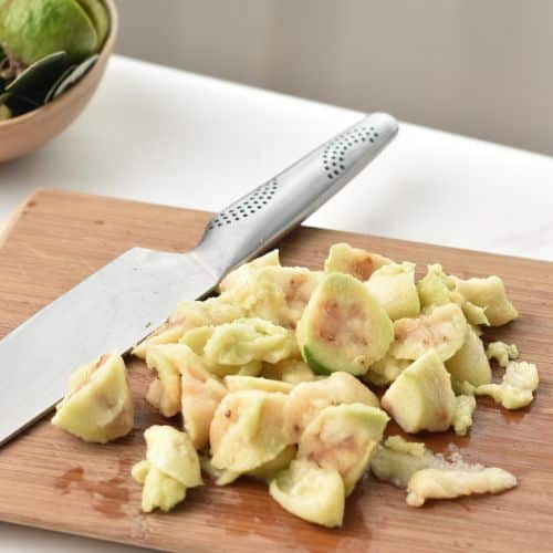 Slicing Feijoa on a wooden board.