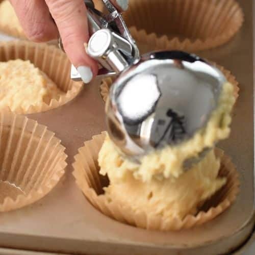 Transferring the Mandarin Muffin batter to the muffin tin with an ice-cream scoop.