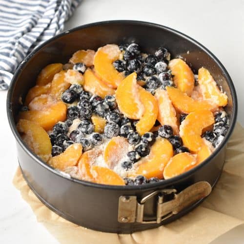 Blueberries and peaches on the cake batter.