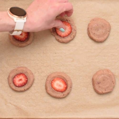 Pressing strawberries on the Almond Flour Strawberry Cookies.