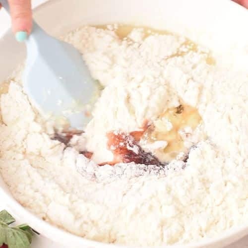 Adding flour to Strawberry Jam Cake ingredients.
