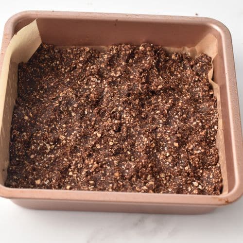 Transferring the Chocolate Granola Bar batter into the pan